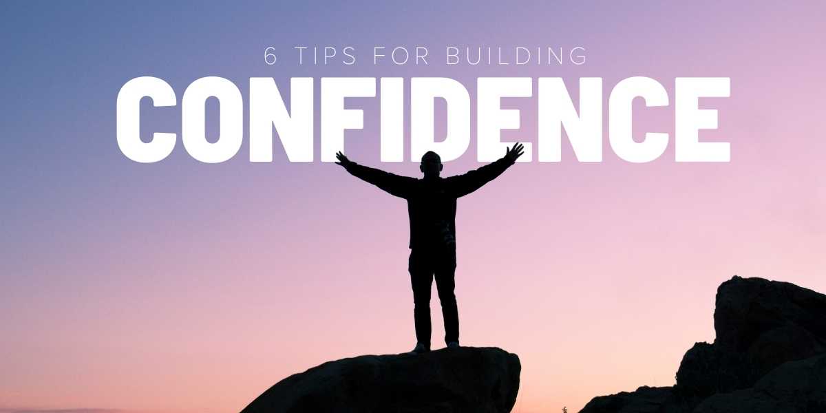6 tips for building confidence shadow standing on rock with arms in air sunset