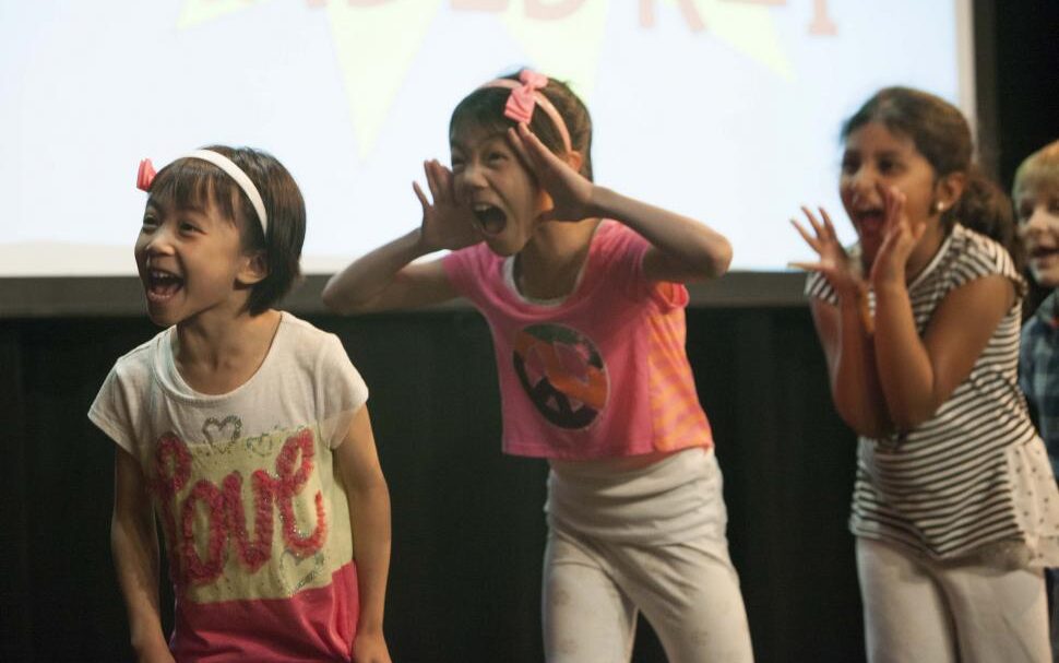 three kids playing theatre games